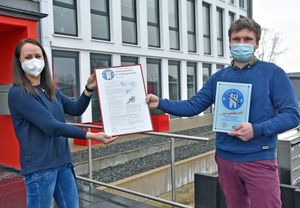 Martin Britt, Leiter der Kita Dedinghausen, nimmt für seine Einrichtung das Zertifikat „Kita mit Biss“ von Prophylaxefachkraft Carolin Grunwald entgegen.  Foto: Stadt Lippstadt