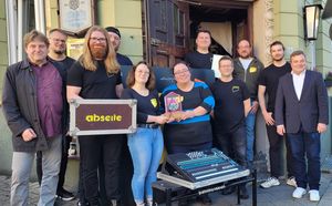 Gemeinsam mit Holger Künemund (l.) überreichte Bürgermeister Arne Moritz (r.) den Heimat-Preis an den Vorsitzenden Lenn Barkey (fünfter v. r.) und die Mitglieder des Vereins „abseite“ an der Musikkneipe „Zum Güterbahnhof“. Foto: Stadt Lippstadt
