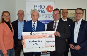 Franz Klocke (dritter v. l.) übergibt gemeinsam mit dem Vorstand von „Pro Lippia“ die Spende in Höhe von 5.000 Euro an den Vorsitzenden Rainer Aust (dritte v. r.) vom Verein Horizontas. Foto: Stadt Lippstadt