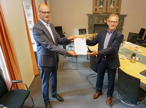 Ferdinand Aßhoff (r.), Leiter der Abteilung III für Regionale Entwicklung, Kommunalaufsicht und Wirtschaft bei der Bezirksregierung Arnsberg, überreichte Bürgermeister Christof Sommer den Förderbescheid für die Digitalisierung des Jahnplatzes. Foto: Stadt Soest