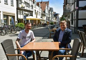 Hoffen, dass sich die Szenen vom vergangenen Wochenende in der Poststraße nicht wiederholen und der Spagat zwischen Kneipenvergnügen und Infektionsschutz ab sofort gelingt: Bürgermeister Arne Moritz (r.) und Poststraßen-Gastronom Christian Hevesi. Foto: Stadt Lippstadt