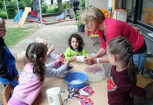 „Saatbomben“-Herstellung mit der Landtagsabgeordneten: Die Kinder der Kita Hörste hatten Spaß beim Mischen und Kneten mit Marlies Stotz. Foto: Stadt Lippstadt