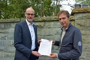 Ulrich Detering, Dezernent für Wasserwirtschaft bei der Bezirksregierung Arnsberg (r.) überreichte Bürgermeister Christof Sommer die Genehmigung für den Umbau der Wehranlage an der Burgmühle. Foto: Stadt Lippstadt