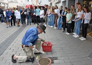 Vor dem Gebäude Lange Straße 63 verlegte Gunter Deming Stolpersteine für Helene und Iwan Hammerschlag. Schülerinnen und Schüler der Marienschule trugen zur Geschichte der Hammerschlags vor. Foto: Stadt Lippstadt