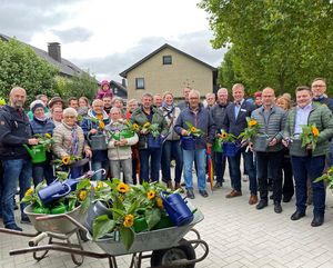 Gemeinsam mit zahlreichen Baumpatinnen und Baumpaten eröffneten Bürgermeister Arne Moritz (r.), Fachbereichsleiter Heinrich Horstmann (zweiter. v. r.) und der Vorsitzende des Umwelt-, Bau- und Mobilitätsausschuss Klaus Fürstenberg (Mitte links mit blauer Gießkanne) den Alleenweg im Lippstädter Südwesten. Foto: Stadt Lippstadt