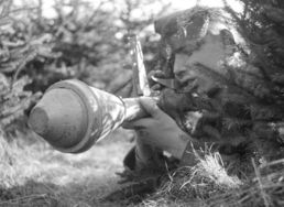 Im Gebüsch versteckter Hitlerjunge mit Raketenwerfer zu Ende des zweiten Weltkriegs in Lippstadt.