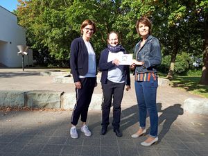 Barbara Bartsch vom Leitungsteam der Conrad-Hansen-Musikschule (m.) überreicht Helga Schäfermeier, Schulleiterin der Grundschule im Kleefeld (r.) und der Konrektorin Ariane Hengstebeck (l.) die „JEKITS Singen Plakette“. Foto: Stadt Lippstadt