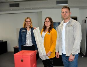 Das Wahlamt im Stadthaus hat geöffnet: (v.l.n.r.) Anja Erlenkötter, Johanna Druffel und Justin Benkel vom Fachdienst Organisation präsentieren die rote Briefwahlurne im Sitzungsraum E.08 im Stadthaus. Foto;: Stadt Lippstasdt