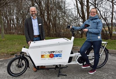 Zuwachs im Zweiradfuhrpark: Baubetriebshofleiter Daniel Utzel und Simone Hövel vom Fachdienst Stadtplanung und Umweltschutz präsentieren das neue Lastenrad, das die städtischen Mitarbeiterinnen und Mitarbeiter ab sofort für Dienstfahrten nutzen können. Foto: Stadt Lippstadt 