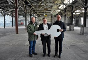 Symbolische Schlüsselübergabe von RNE-Geschäftsführer Benjamin Seiger (l.) an Bürgermeister Arne Moritz (M.) und Heinrich Horstmann, Fachbereichsleiter Stadtentwicklung und Bauen: Nach dem erfolgreichen Abschluss des Kaufvertrages ist die Stadt Lippstadt jetzt Eigentümerin einer gut sechs Hektar großen Fläche auf dem ehemaligen Uniongelände. Foto: Stadt Lippstadt