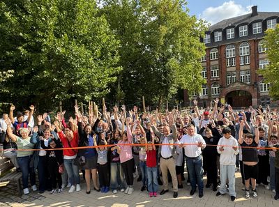 Auf „Drei“: Schülerinnen und Schüler schnitten das Band bei der offiziellen Einweihung des Schulhofes der Schule Im Grünen Winkel durch. Foto: Stadt Lippstadt