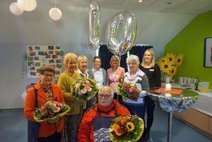 Beim Treffen im Mehrgenerationenhaus Mikado würdigten Iris Faulhaber (rechts hinten) und Sylvia Helmig (dritte v. r.) das langjährige Engagement der Spazierpaten (v. l.) Rita Lemke, Ursula Surrey Ingeborg Motog und Hans-Werner Koch (vorne) und freuten sich gemeinsam mit Ehrengast Anita Polder (vierte v. r.) über das erfolgreiche Projekt. Foto. Stadt Lippstadt
