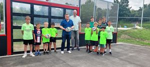 Arne Moritz und Hans Koch freuen sich gemeinsam mit den Kindern und Jugendlichen des SuS Cappel über die neue digitale Torwand am Jahnplatz. Foto: Stadt Lippstadt