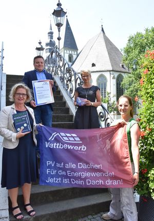 Bürgermeister Arne Moritz und Birgit Specovius vom Fachdienst Stadtplanung und Umweltschutz (zweite v. r.) freuen sich über den Quartals-Award für Lippstadt. Übergeben wurde der Award durch Sandra Schankweiler vom Orga-Team des „Wattbewerbs“ (rechts vorne). Ebenfalls anwesend war Anke Viktor vom Klimanetzwerk Lippstadt (links vorne). Foto: Stadt Lippstadt