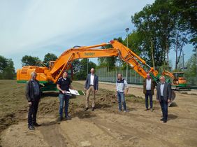 Alles vorbereitet für den Einbau des Kunstrasenplatzes: Bernhard Hörstmann-Jungemann (Ratsmitglied), Klaus Böhm von der Koordinierungsstelle Sport, Bürgermeister Christof Sommer, Christian Eikmeyer (heiler Sportplatzbau), Christian Deppen (Ingenieurbüro Brinkmann + Deppen) und Dedinghausens Ortsvorsteher Bernhard Schäfers auf dem Geländes des Sportplatzes, auf dem jetzt der neue Kunstrasen eingebaut wird. Foto: Stadt Lippstadt