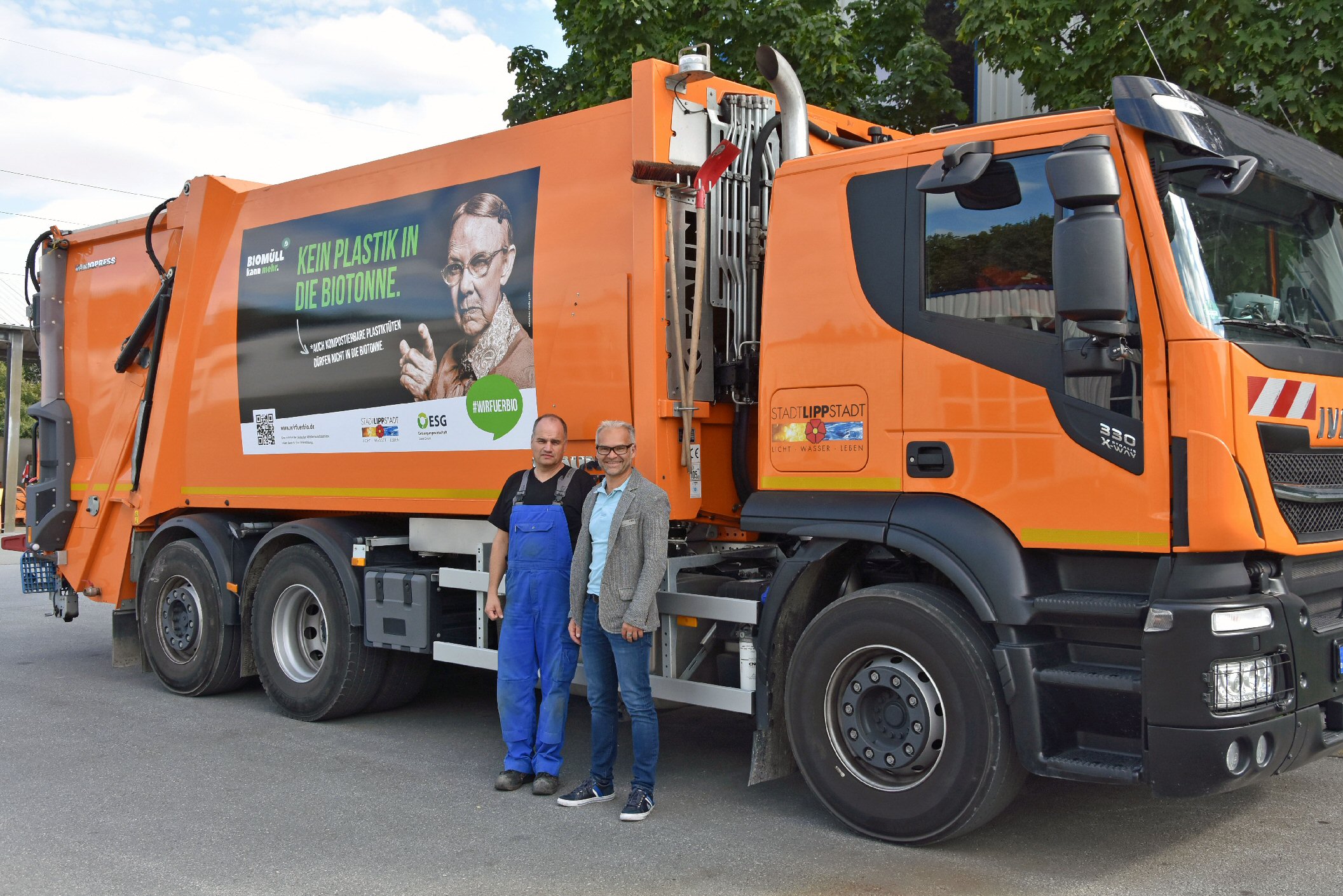 Baubetriebshofleiter Daniel Utzel (r.) und Werkstattleiter Reiner Buddeus mit einem der beiden Müllfahrzeuge auf die das Motiv der #wirfuerbio-Kampagne aufgebracht worden ist. Foto: Stadt Lippstadt