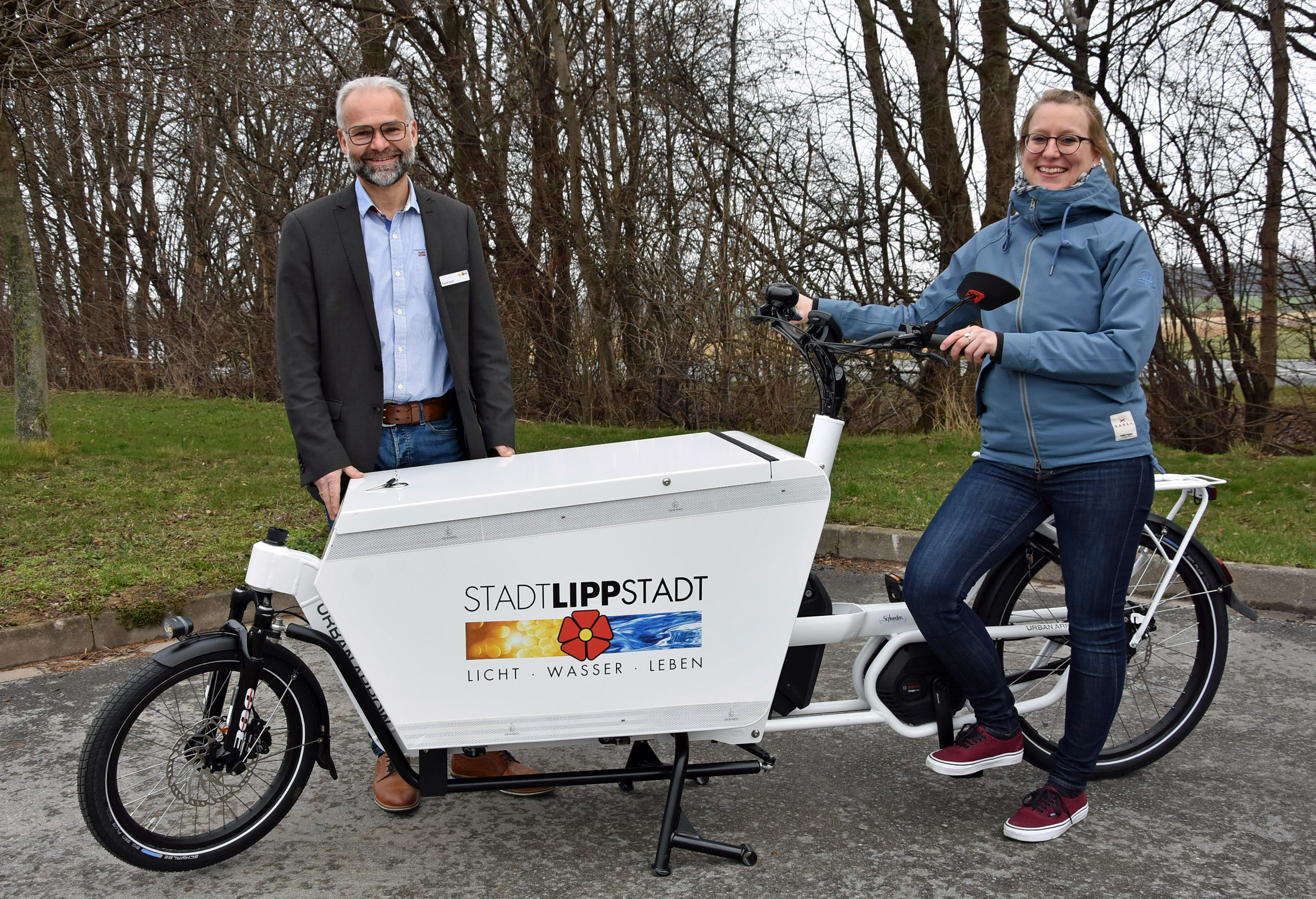 Zuwachs im Zweiradfuhrpark: Baubetriebshofleiter Daniel Utzel und Simone Hövel vom Fachdienst Stadtplanung und Umweltschutz präsentieren das neue Lastenrad, das die städtischen Mitarbeiterinnen und Mitarbeiter ab sofort für Dienstfahrten nutzen können. Foto: Stadt Lippstadt 