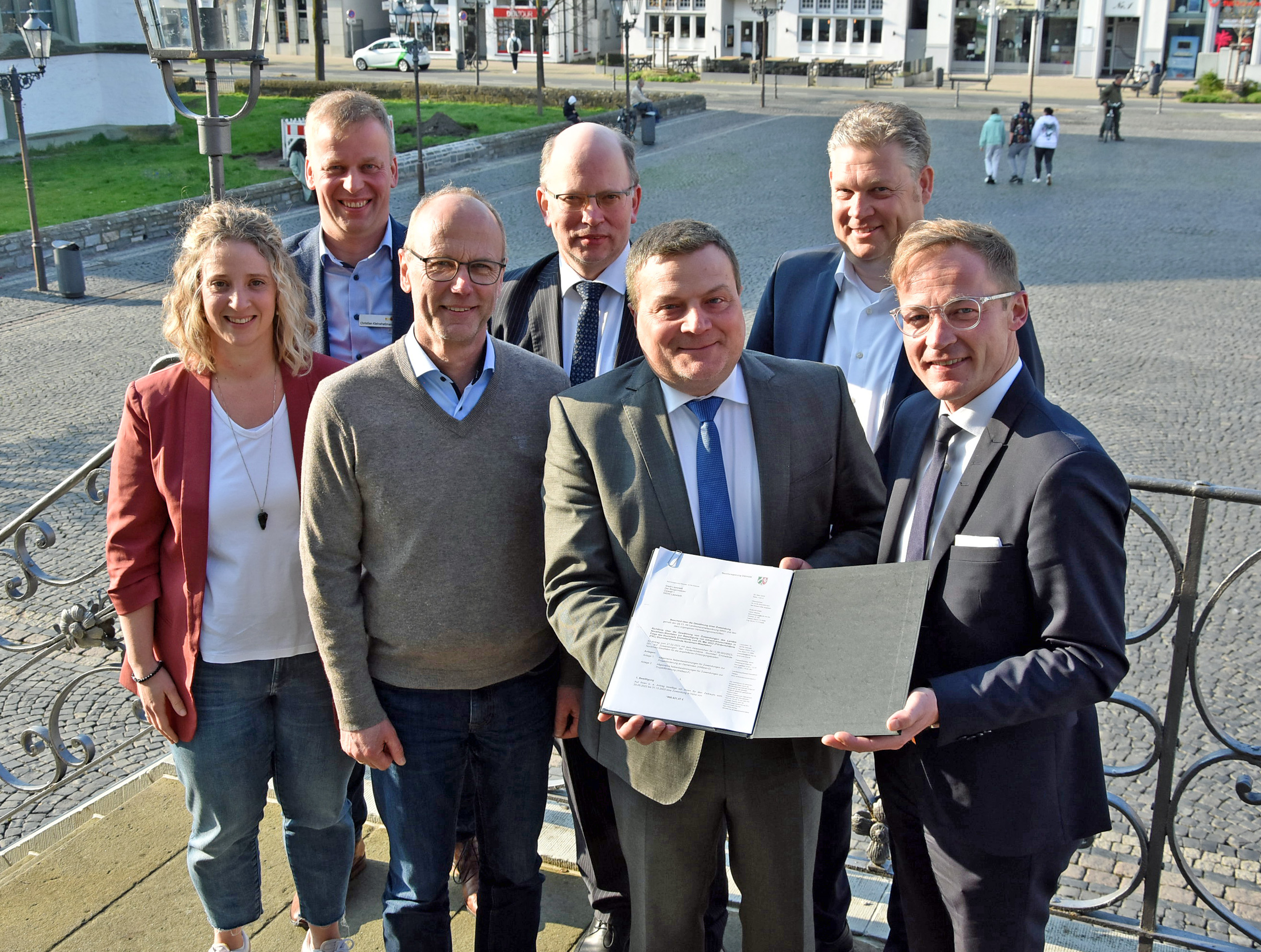 Staatssekretär Daniel Sieveke (r.) überreichte den ersten Förderbescheid des Landes NRW zur Beseitigung der Tornadoschäden an Bürgermeister Arne Moritz, der sich mit den Verantwortlichen aus der Fachverwaltung (v.l.) Michaela Lange, Christian Kleineheilmann und Heinrich Horstmann sowie dem Ersten Beigeordneten Stephan Tydecks und dem Landtagsabgeordneten Jörg Blöming über die erste „Finanzspritze“ freut. Foto: Stadt Lippstadt