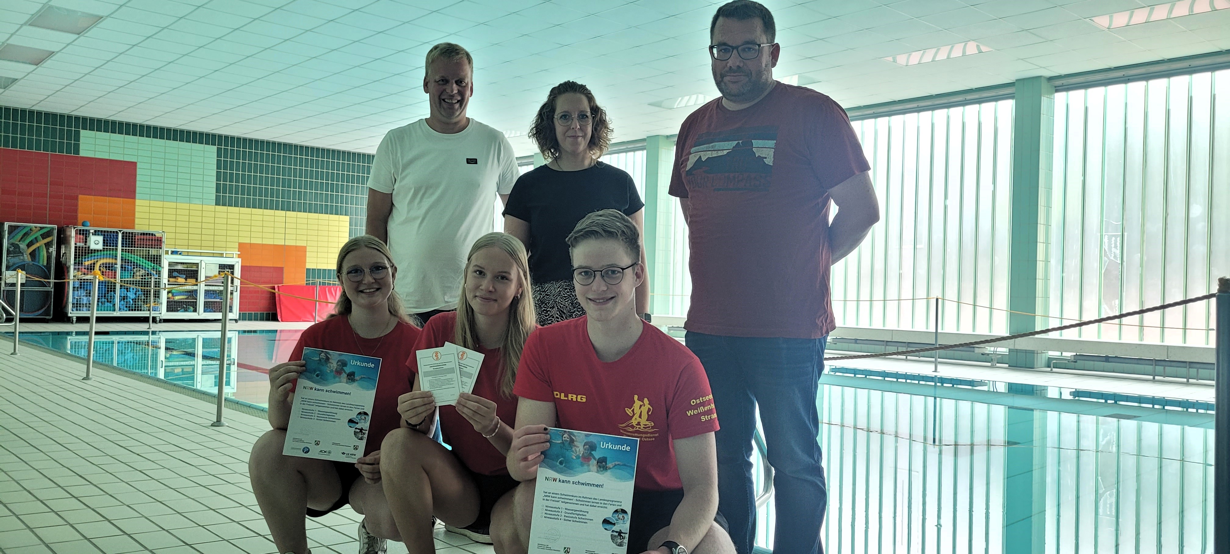 Freuen sich über erfolgreiche Schwimmkurse im Rahmen des Programms „NRW kann schwimmen“: Übungsleiter Sarah Auge, Merle Gravendyck und Mats Dicke (vorne, v.l.n.r.) sowie Fachdienstleiter Christian Kleineheilmann (hinten, l.) und Marius Hiedels (hinten r.) vom Fachdienst Grünflächen, Spielen und Sport und Sylvia Hof vom Kreissportbund Soest (hinten, m.) Foto: Stadt Lippstadt