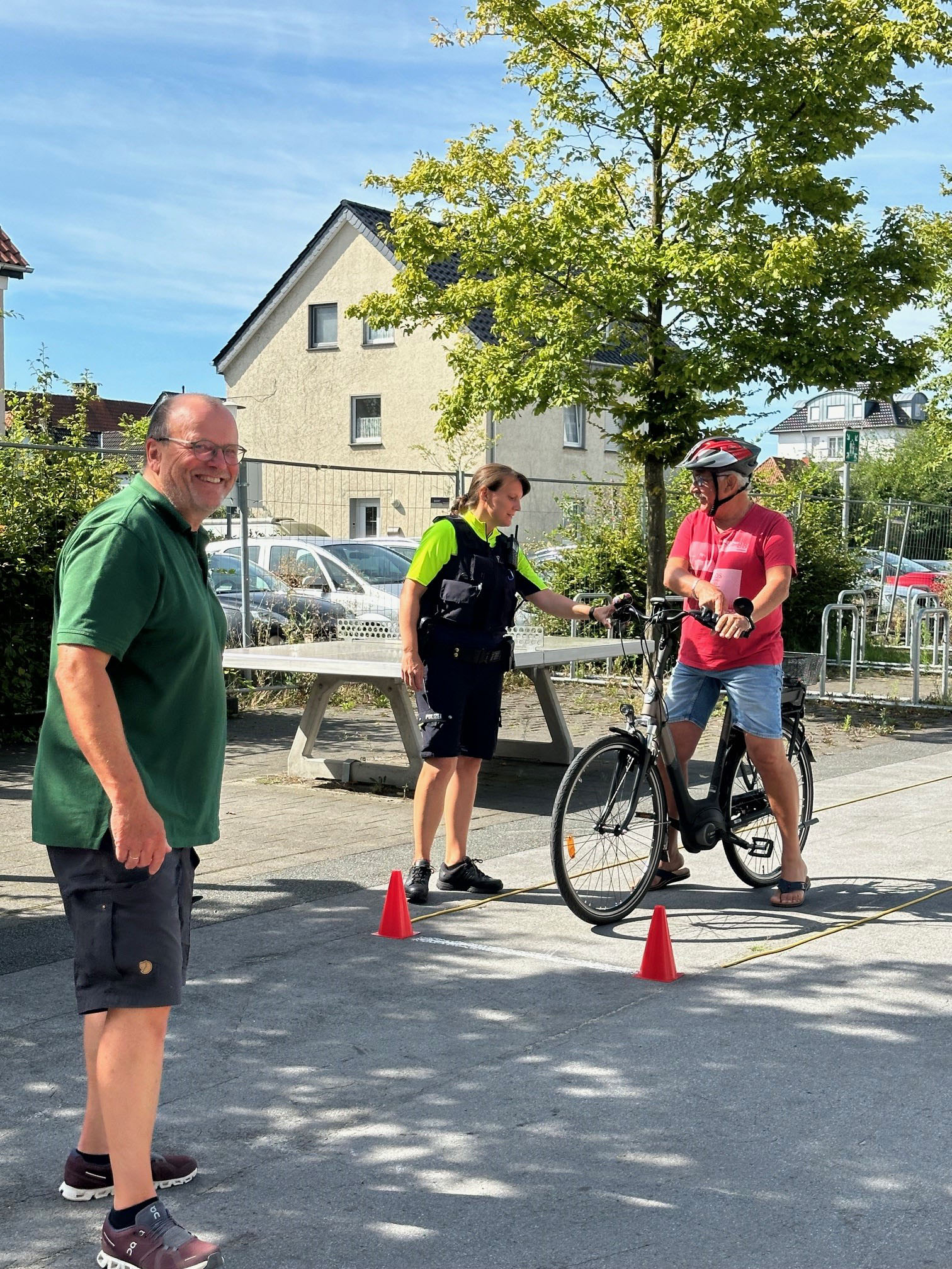 Yvonne Schomacher erklärt Bernhard Bartscher die Bremsen am Lenker. Heinz Großekathöfer (vorne links) von der Verkehrswacht freut sich über die mutige Umsetzung der Übungen durch die Senioren. Foto: Stadt Lippstadtt
